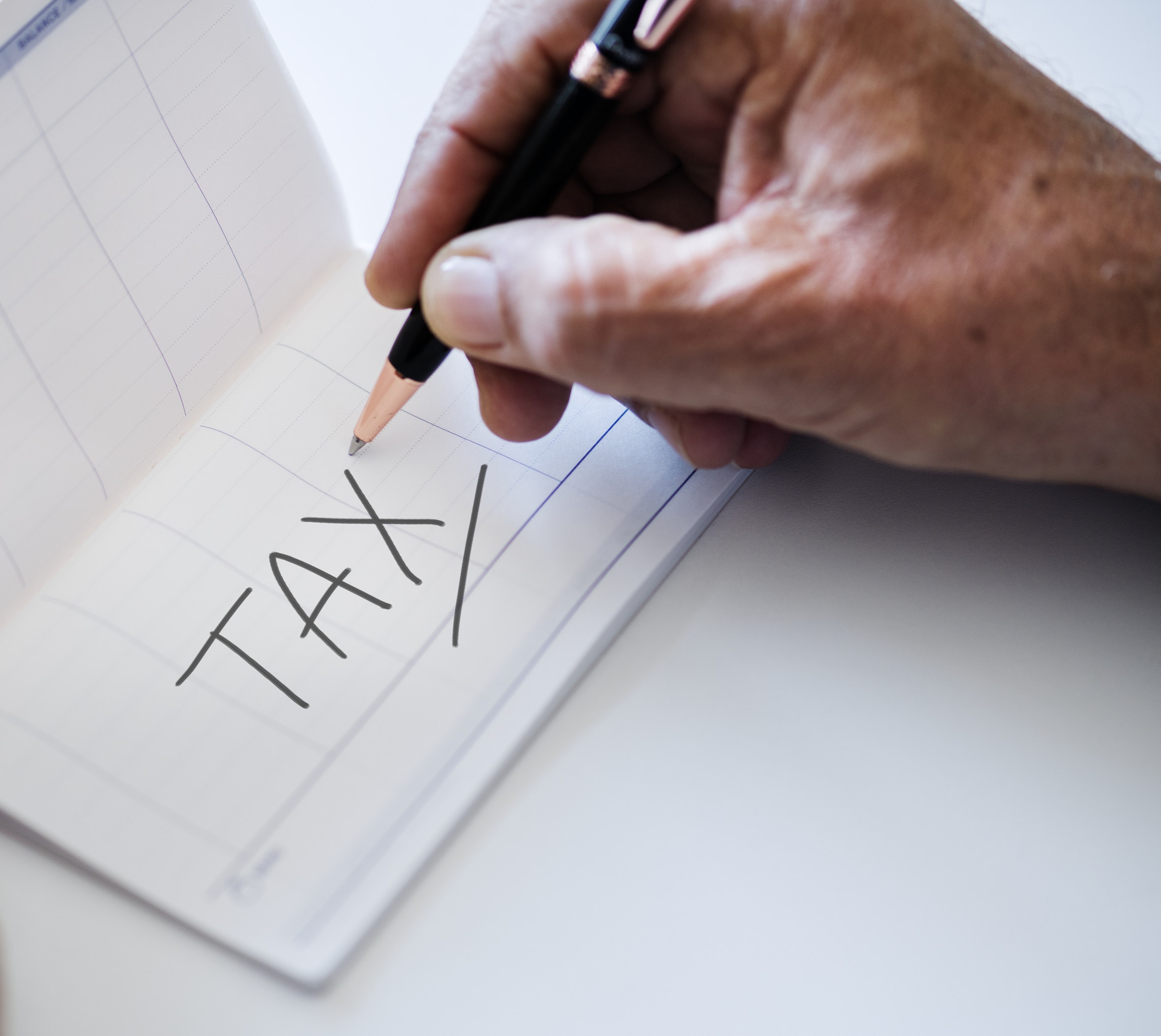 Hand writing TAX in ledger